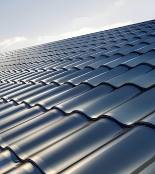 This close-up photograph, taken from a low angle with a stretched perspective, showcases a modern, large-scale BIPV (Building Integrated Photovoltaic) curved roof system. The image is filled with a neat, uniform matrix of countless horizontally interlocking and vertically layered, deep black solar curved photovoltaic tiles (PV tiles). The tiles extend infinitely from the lower left to the upper right, forming a wavy, undulating, streamlined surface with a composite texture of metal and glass. Each curved tile surface is extremely smooth and delicate, reflecting long, soft, bright white specular highlights under bright natural sunlight, subtly revealing the highly integrated dark monocrystalline silicon or thin-film photovoltaic material structure within the tile. A corner of exceptionally clear sky peeks out in the upper left corner, bathed in soft, pale blue and golden sunlight. The entire photo is free of unnecessary architectural clutter, with a clear distinction between primary and secondary elements, and is well-organized and grand. It perfectly combines the streamlined aesthetics of traditional roof tiles with cutting-edge distributed solar energy technology, showcasing the technological quality of high-end clean energy building materials and the environmentally friendly aesthetic atmosphere of modern low-carbon living.