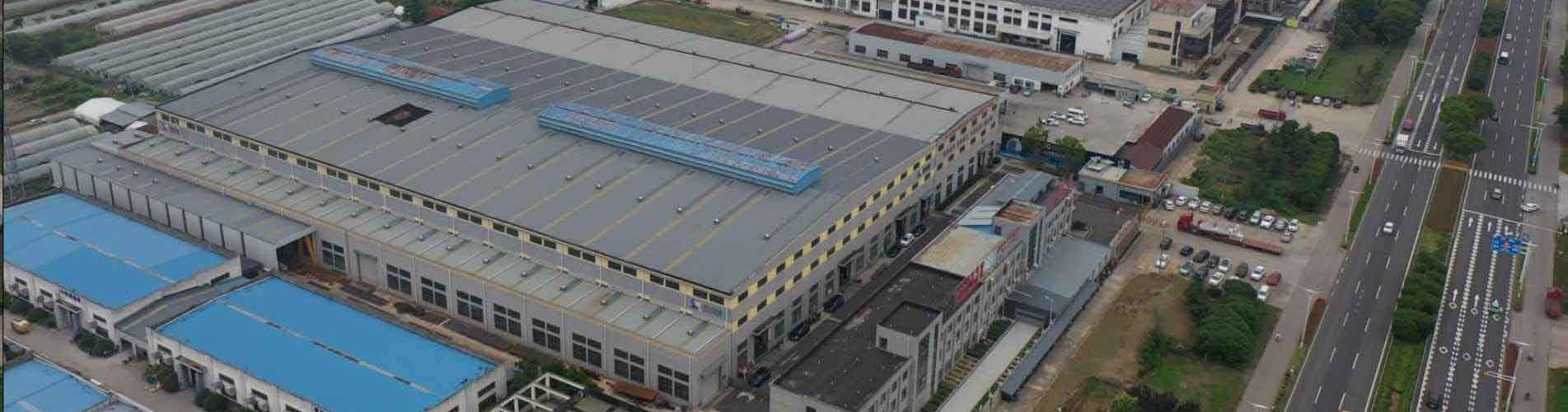 This aerial photograph, taken by a drone from a high altitude using an ultra-wide panoramic bird's-eye view, showcases the panoramic view of GreenMore's modern BIPV solar tile manufacturing industrial park. The image shows multiple massive industrial buil