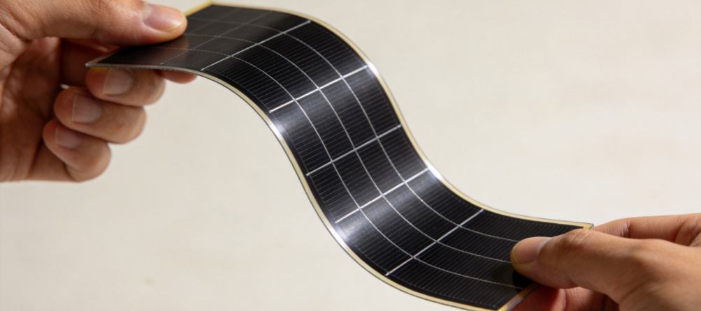 GreenMore's high-efficiency, lightweight, flexible thin-film solar cells are shown being held and bent by both hands.