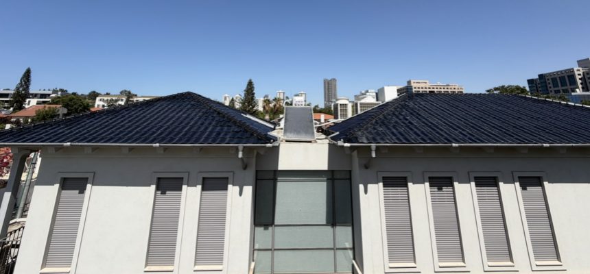 The completed BIPV solar roof on the Netanya house showing 407 triple-arch curved solar tiles fully installed across all four aspects with clean ridge lines and integrated waterproofing
